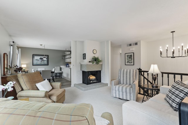living area with a fireplace, a notable chandelier, and visible vents