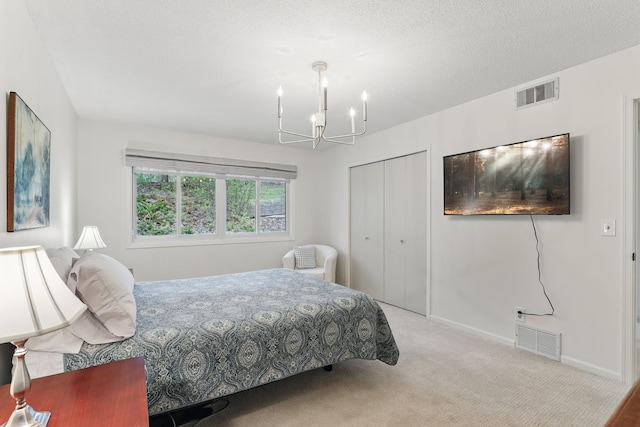bedroom with an inviting chandelier, carpet floors, a closet, and visible vents