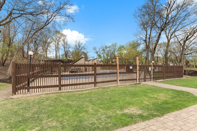 view of gate with fence and a yard
