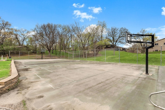 view of sport court featuring a lawn, community basketball court, and fence