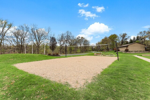 view of property's community featuring a yard and volleyball court