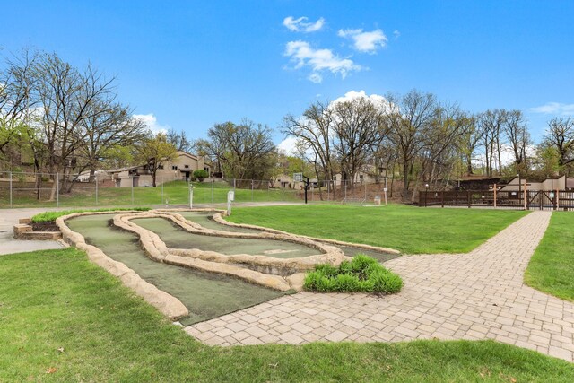 surrounding community with a lawn and fence