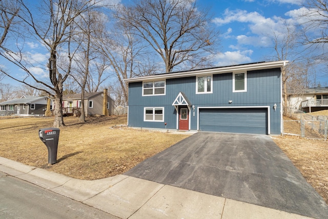 view of front of house with a garage, a front lawn, aphalt driveway, and fence