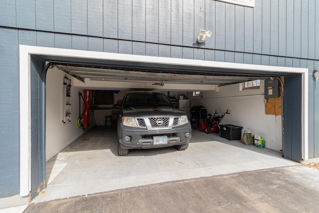 garage featuring electric panel and concrete driveway