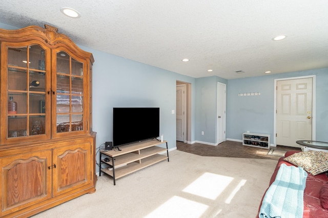 carpeted living room with recessed lighting, a textured ceiling, and baseboards