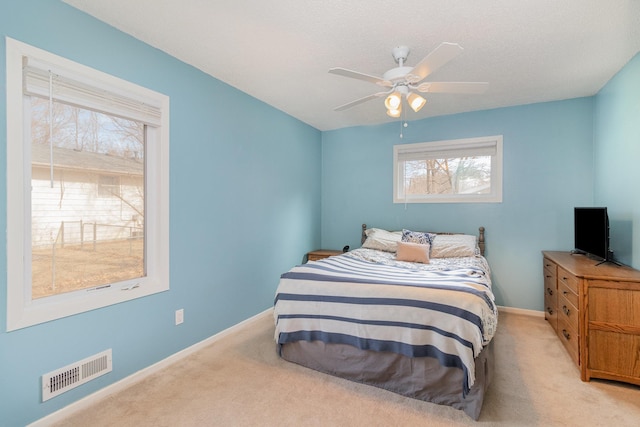 bedroom featuring carpet floors, a ceiling fan, baseboards, and visible vents