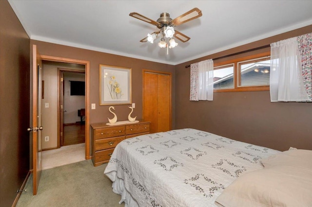 bedroom with ceiling fan, light carpet, baseboards, and a closet