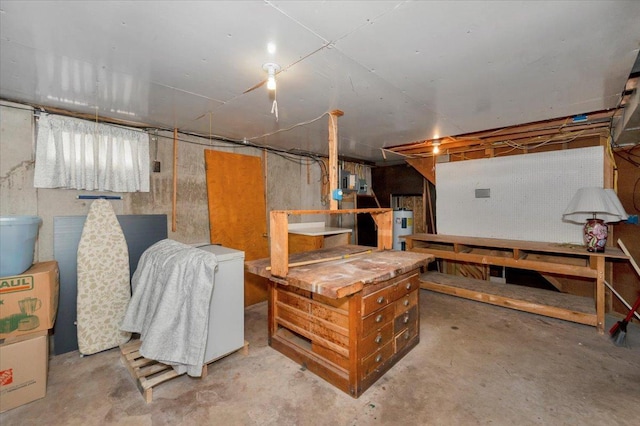 unfinished basement featuring refrigerator and electric water heater
