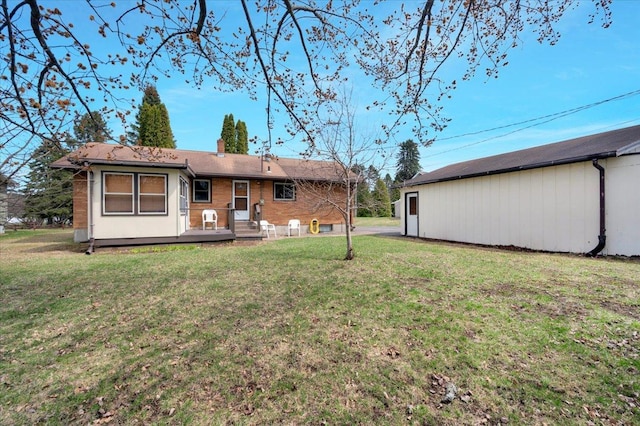 rear view of property with a yard, brick siding, and a chimney
