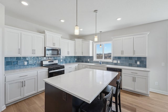 18357 Glacier Way, Lakeville, MN 55044 - kitchen featuring appliances with stainless steel finishes, a sink, light countertops, white cabinetry, and tasteful backsplash
