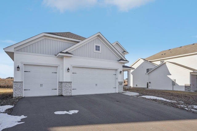 18357 Glacier Way, Lakeville, MN 55044 - view of front of home with a garage, aphalt driveway, board and batten siding, and stone siding