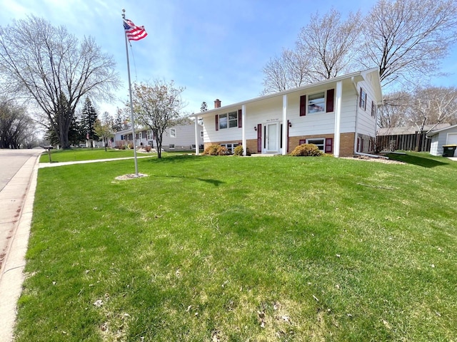 view of front of property with a chimney, brick siding, and a front lawn