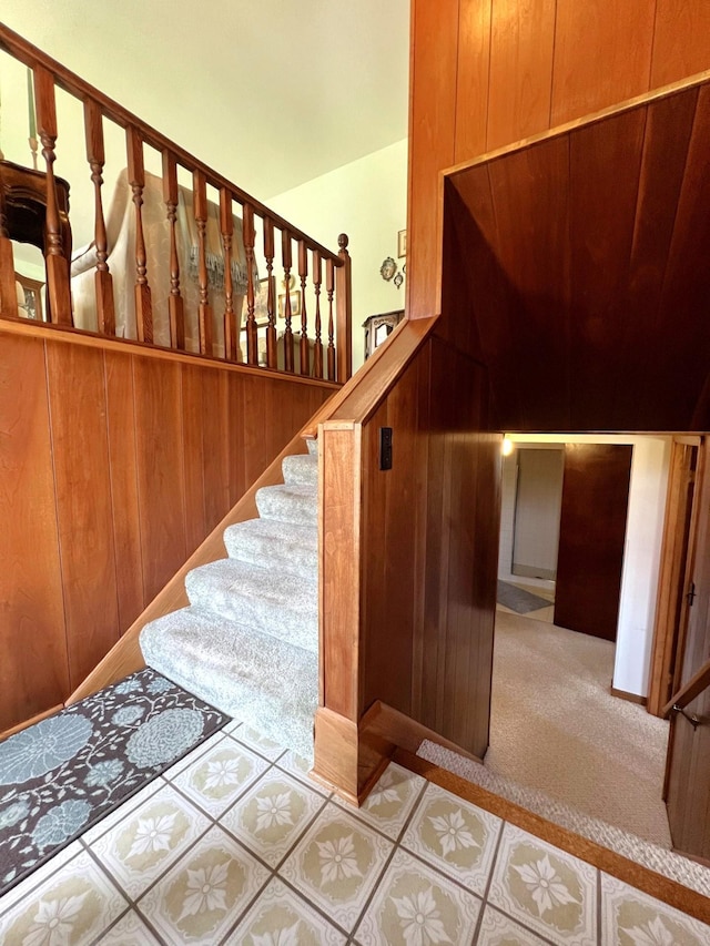 stairs with wood walls and carpet floors