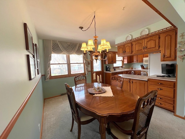 dining area featuring a chandelier and light carpet