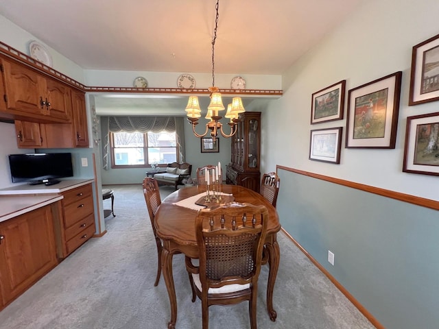 dining room with a chandelier and light colored carpet