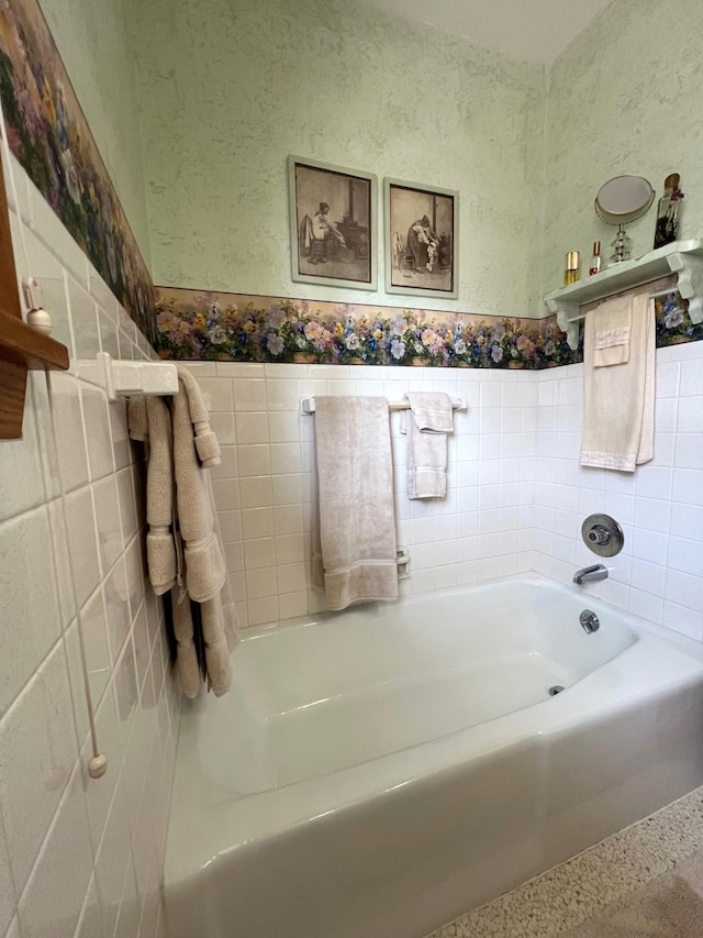 full bath with tile walls, a bath, speckled floor, and wainscoting