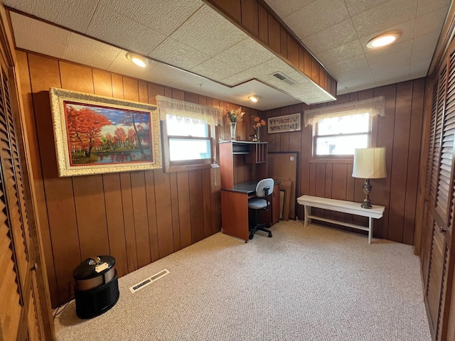 home office featuring light colored carpet and wooden walls