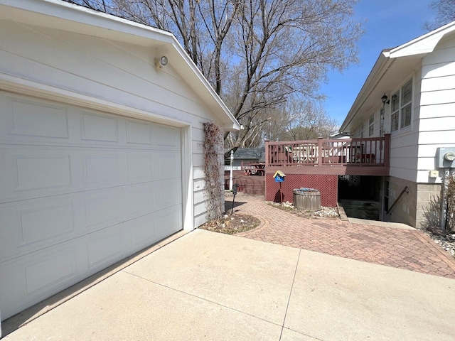 view of property exterior featuring a deck, driveway, and a garage