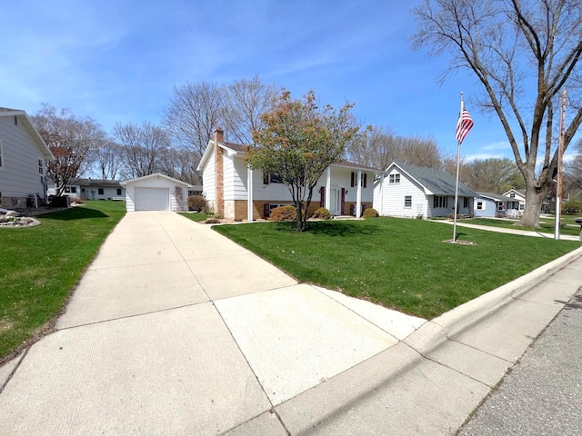 view of front facade with an outdoor structure, a chimney, a front yard, and a detached garage