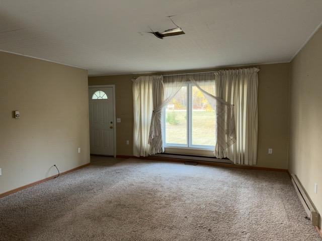6231 164th St NW, Cass Lake, MN 56633 - empty room with baseboards, a baseboard radiator, and carpet