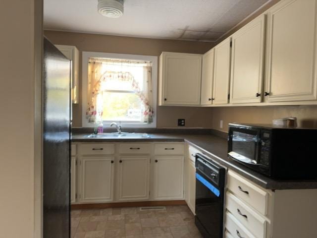 6231 164th St NW, Cass Lake, MN 56633 - kitchen featuring a sink, dark countertops, black appliances, and white cabinetry