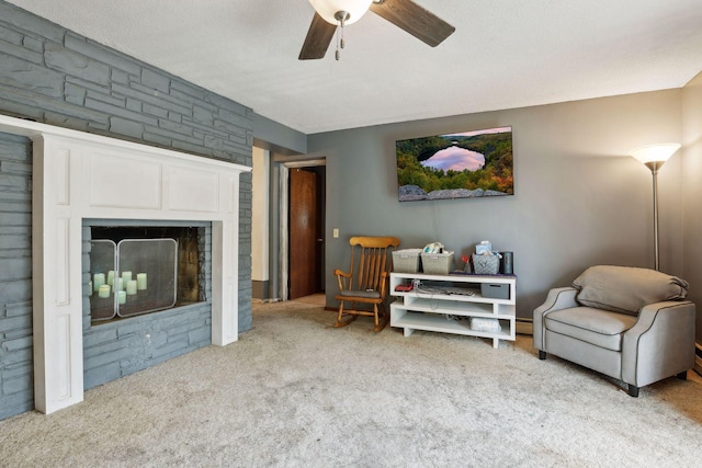 carpeted living area with a fireplace and a ceiling fan