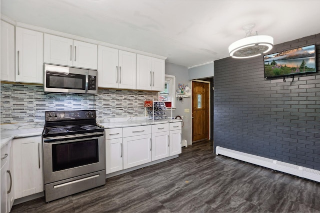 kitchen featuring decorative backsplash, appliances with stainless steel finishes, brick wall, and white cabinets