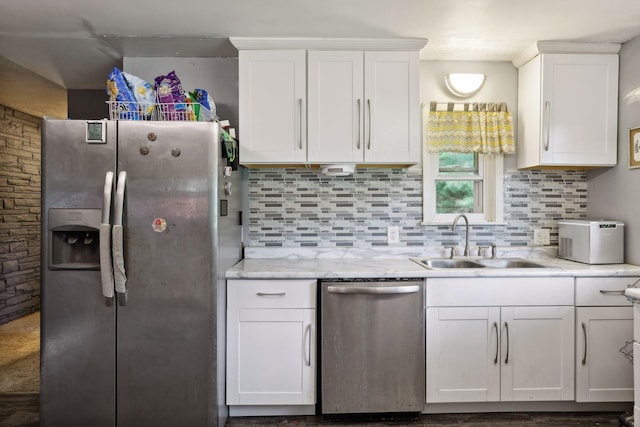 kitchen featuring a sink, appliances with stainless steel finishes, tasteful backsplash, and white cabinetry