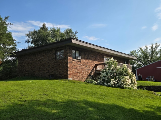 view of side of property featuring brick siding and a yard