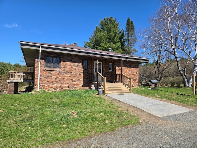 view of front facade with brick siding and a front yard