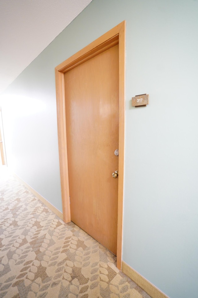 hall with baseboards and carpet