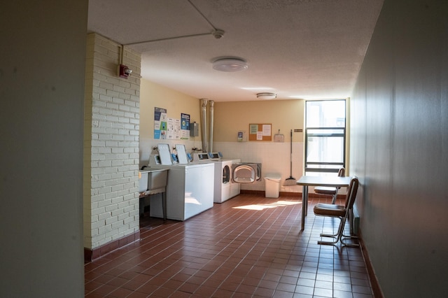 community laundry room with separate washer and dryer, baseboards, and tile patterned flooring