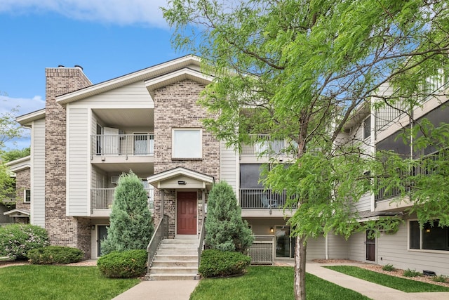 2110 Ridge Dr Unit 11, Saint Louis Park, MN 55416 - view of front of house featuring brick siding, a front yard, and a chimney