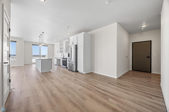 unfurnished living room featuring baseboards and light wood-style floors