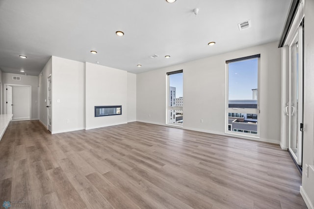 unfurnished living room with recessed lighting, visible vents, and light wood-style flooring