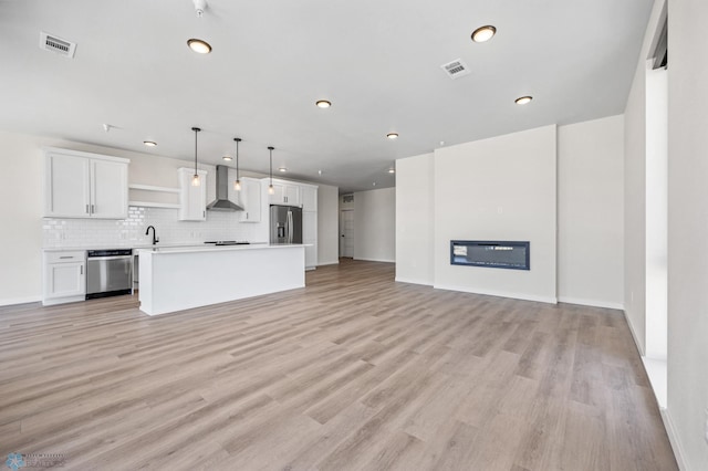 unfurnished living room featuring recessed lighting, light wood finished floors, and visible vents