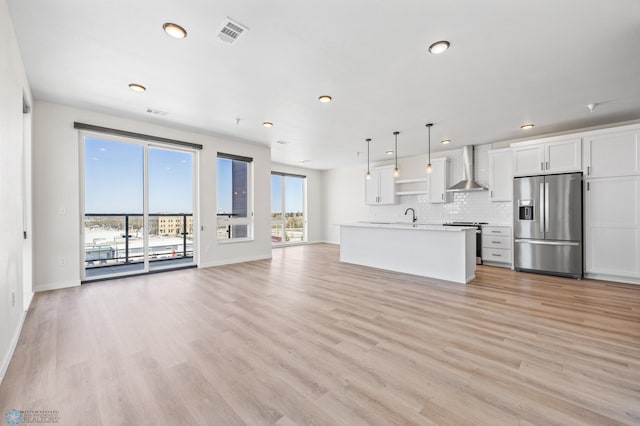 unfurnished living room featuring recessed lighting, baseboards, light wood finished floors, and visible vents