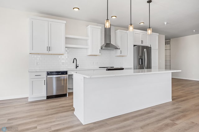 kitchen with wall chimney range hood, open shelves, light countertops, stainless steel appliances, and a kitchen island