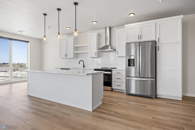 kitchen featuring open shelves, wall chimney range hood, white cabinetry, a sink, and appliances with stainless steel finishes