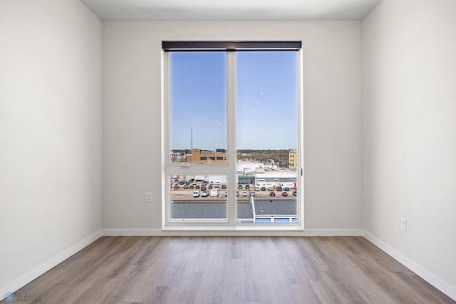unfurnished room featuring baseboards and wood finished floors