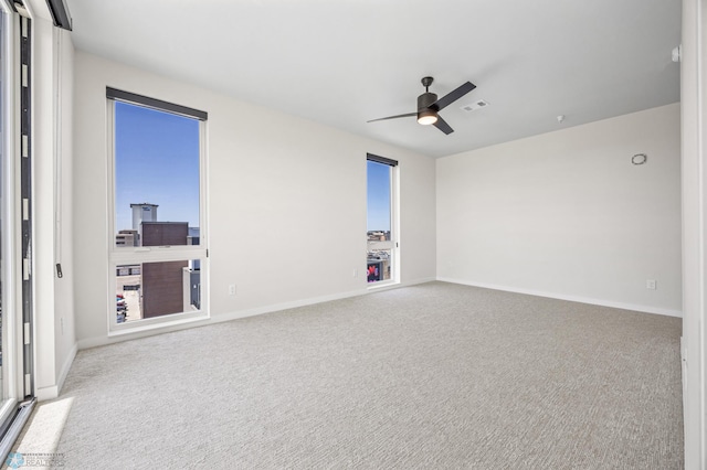 unfurnished room featuring visible vents, carpet, ceiling fan, and baseboards