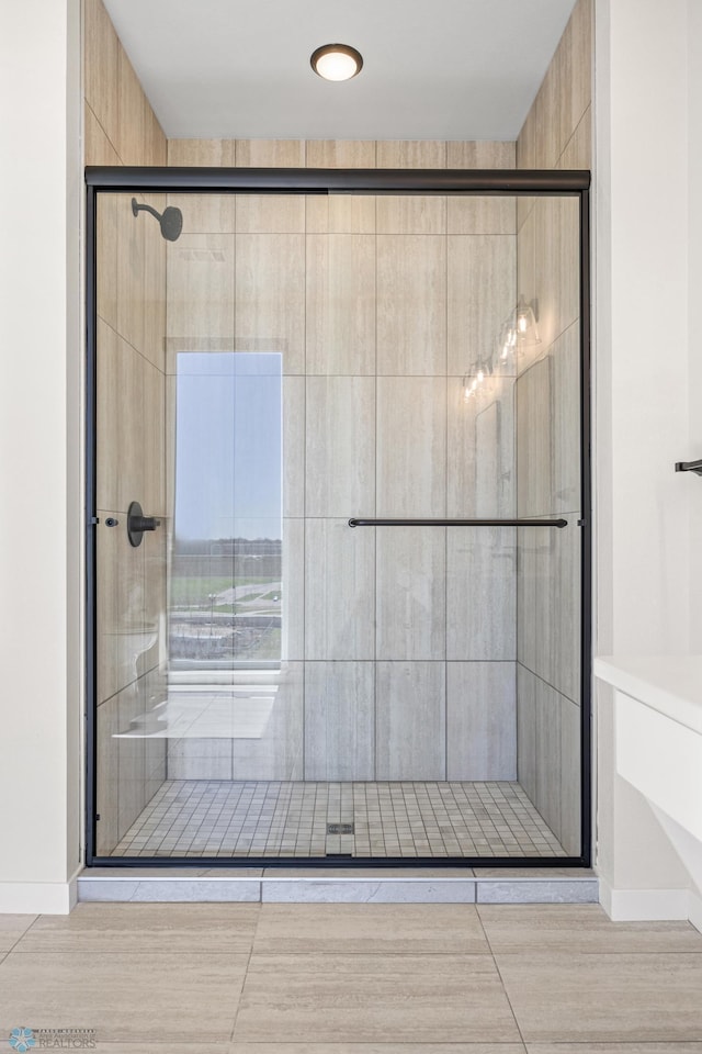 bathroom featuring baseboards and a tile shower