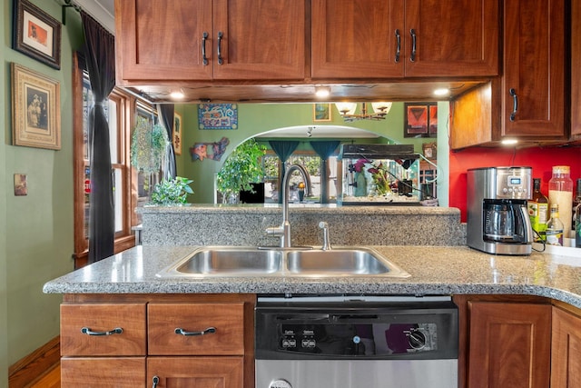 kitchen featuring brown cabinets, light stone countertops, a sink, and dishwasher