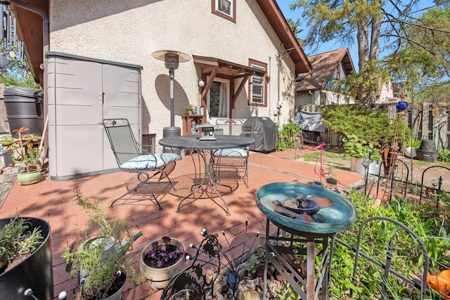 view of patio / terrace featuring fence, outdoor dining space, and a grill