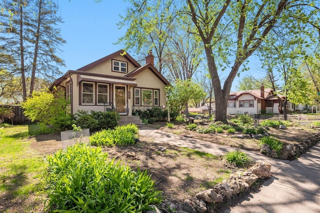 view of front of property featuring fence, stucco siding, and a chimney