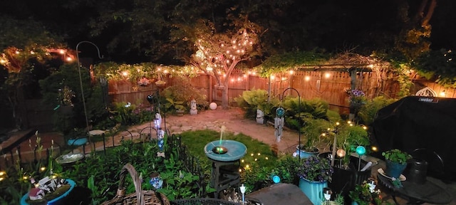 yard at night with a fenced backyard