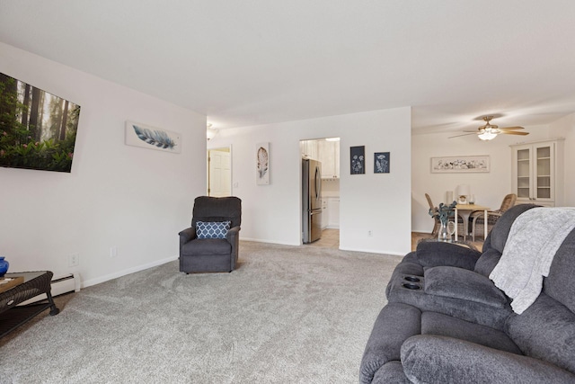 living area featuring a ceiling fan, baseboards, light carpet, and a baseboard radiator