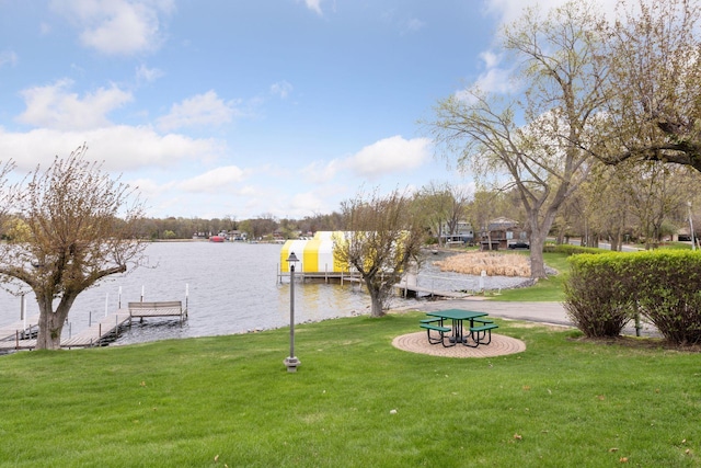 dock area with a lawn and a water view
