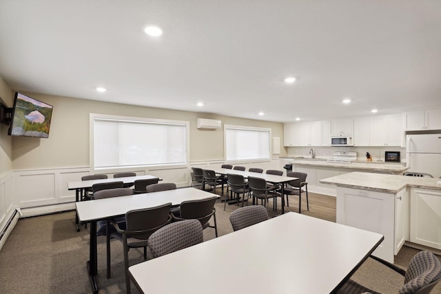 dining space featuring recessed lighting, wainscoting, and a decorative wall