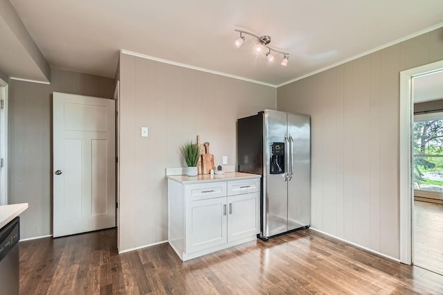 kitchen featuring stainless steel appliances, light countertops, wood finished floors, white cabinetry, and crown molding